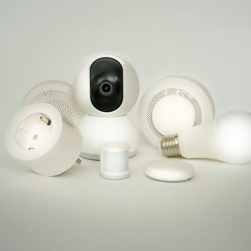 A collection of smart home devices including bulbs, sockets, and cameras on a white backdrop.